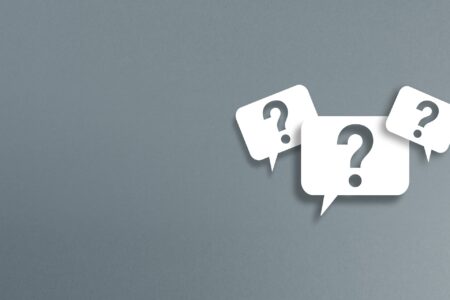 FAQ - Frequently Asked Questions - three white speech bubbles with a cut-out question mark on a gray background